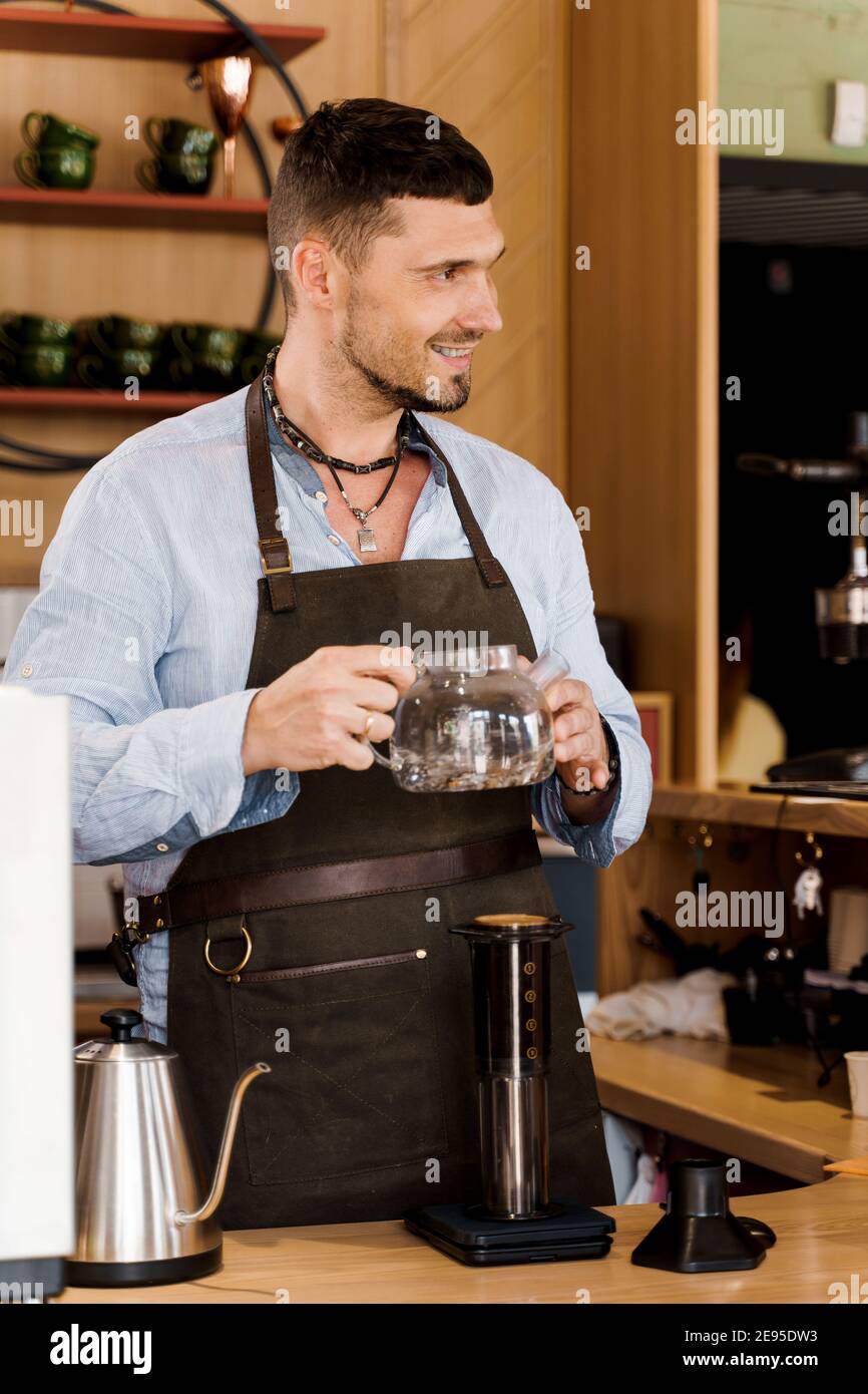 https://c8.alamy.com/comp/2E95DW3/aeropress-coffee-and-handsome-bearded-barista-in-cafe-barisa-cook-tasty-coffee-using-alternative-brewing-method-vertical-photo-for-advert-in-social-2E95DW3.jpg