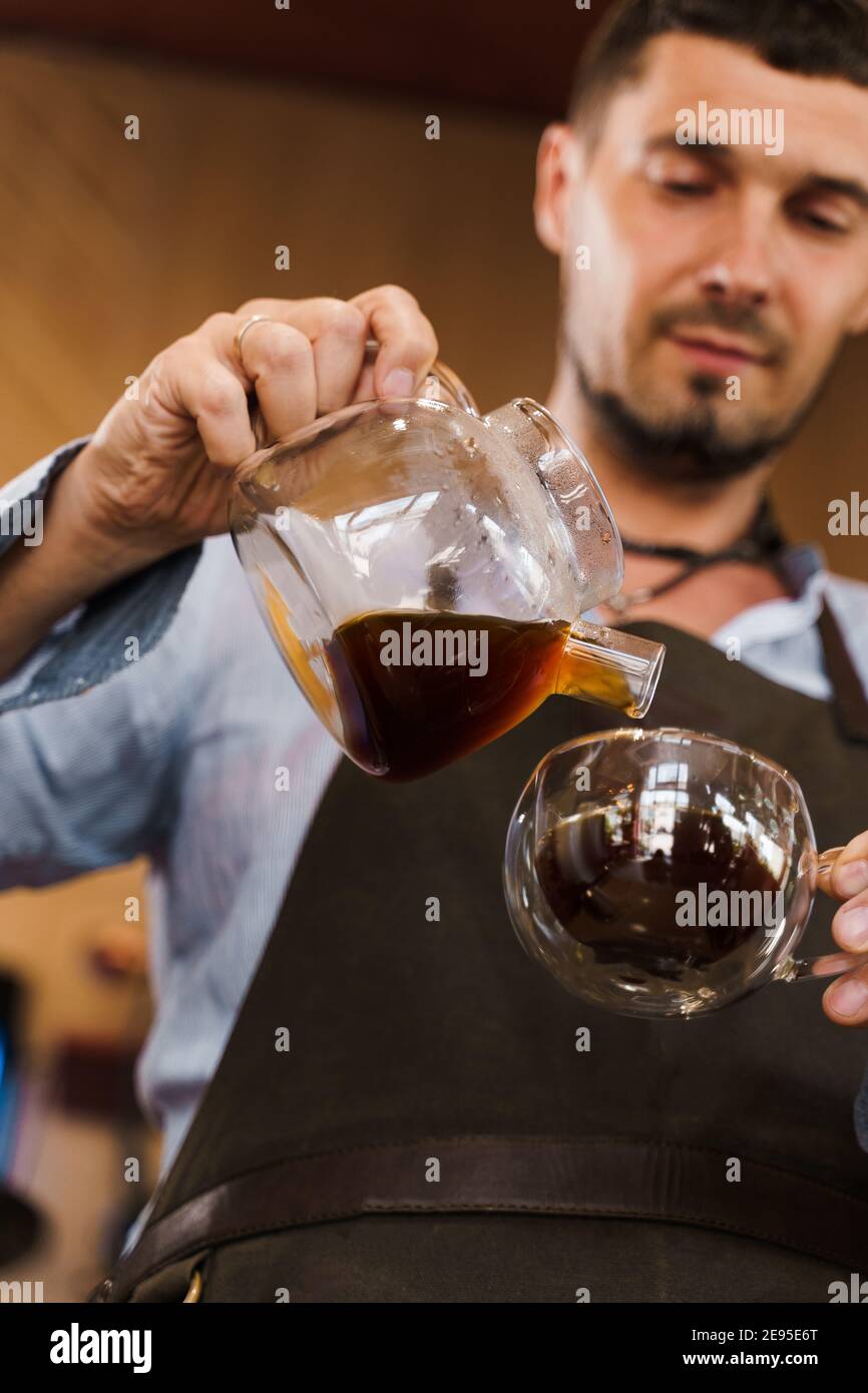 Aeropress coffee: barista press to device and coffee drops pours trought  aeropress to pot. Alternative coffee brewing method. Vertical photo  handsome Stock Photo - Alamy