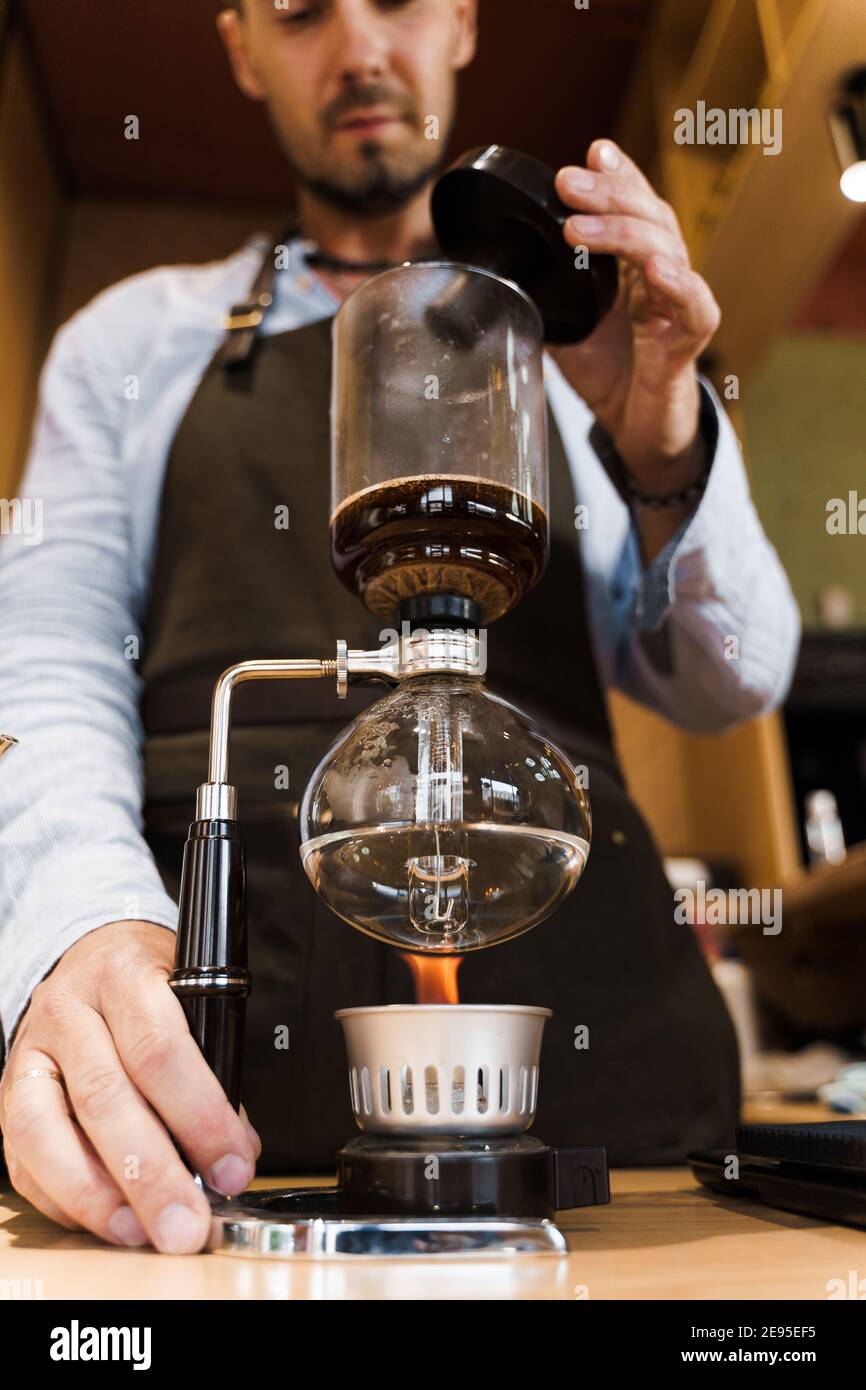 https://c8.alamy.com/comp/2E95EF5/syphon-coffee-brewing-process-close-up-syphon-is-heating-by-fire-brewing-photo-on-the-fire-alternative-method-of-coffee-making-vertical-photo-for-2E95EF5.jpg