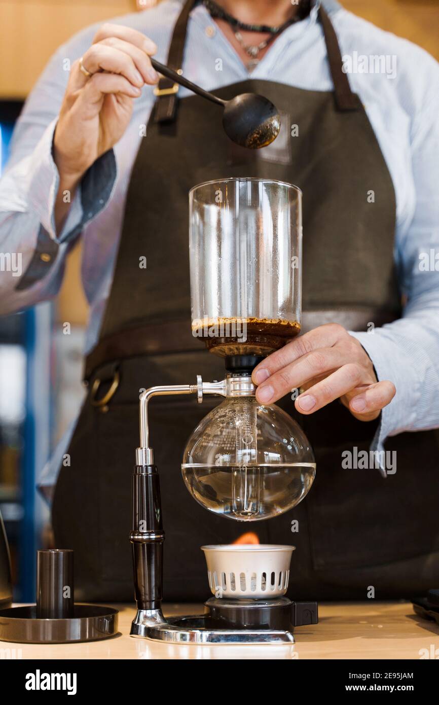 Coffee brewing by Syphon device. Close up syphon is heating by fire