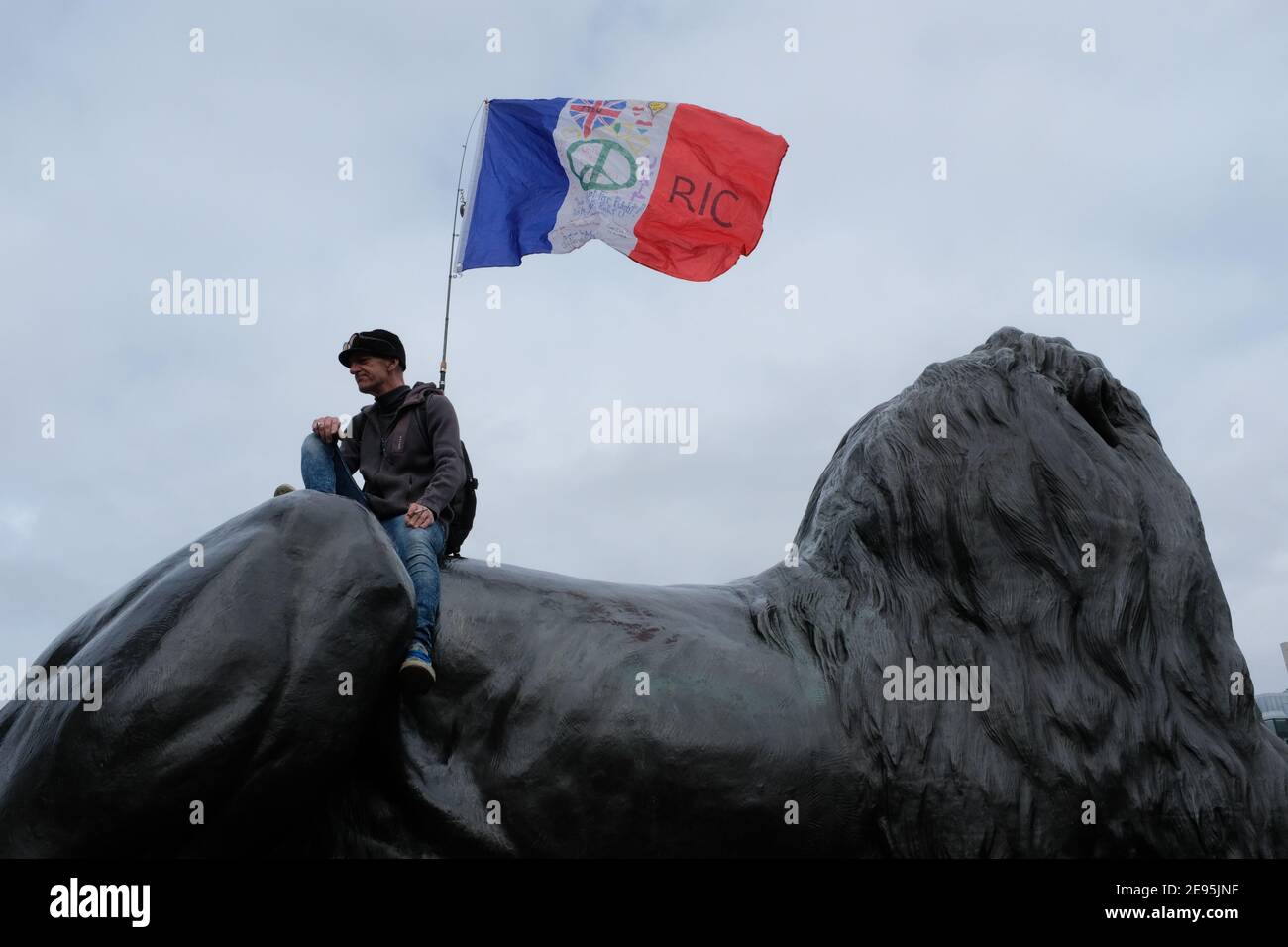 23RD MARCH 2019: A french RIC protester (Citizens' Initiative Referendum) sits on top of a Landseer Lion on Trafalgar Square in London. Stock Photo