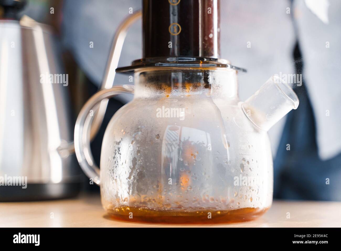 https://c8.alamy.com/comp/2E95K4C/aeropress-coffee-barista-press-to-device-and-coffee-drops-pours-trought-aeropress-to-pot-alternative-coffee-brewing-method-handsome-bearded-barista-2E95K4C.jpg