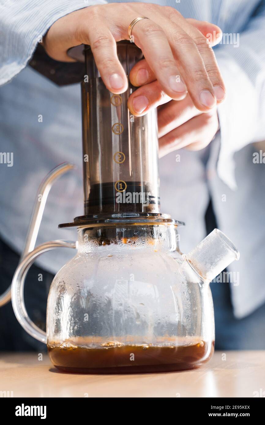 https://c8.alamy.com/comp/2E95KEX/aeropress-coffee-barista-press-to-device-and-coffee-drops-pours-trought-aeropress-to-pot-alternative-coffee-brewing-method-vertical-photo-handsome-2E95KEX.jpg