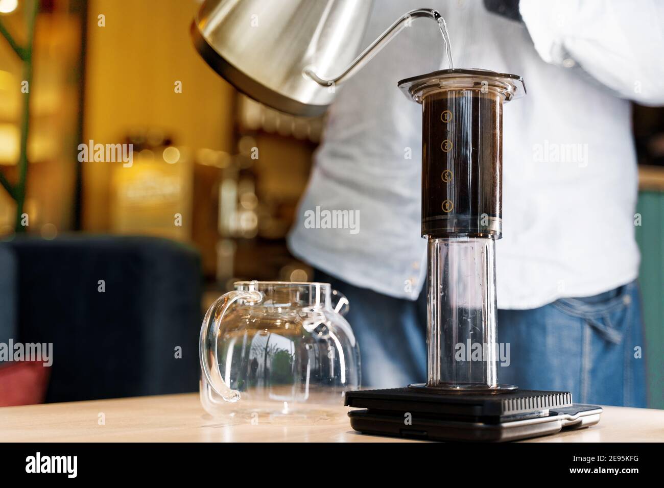 Aeropress coffee close up alternative making by barista in the cafe.  Scandinavian coffee brewing method. Barista pours water to aeropress with  coffee Stock Photo - Alamy