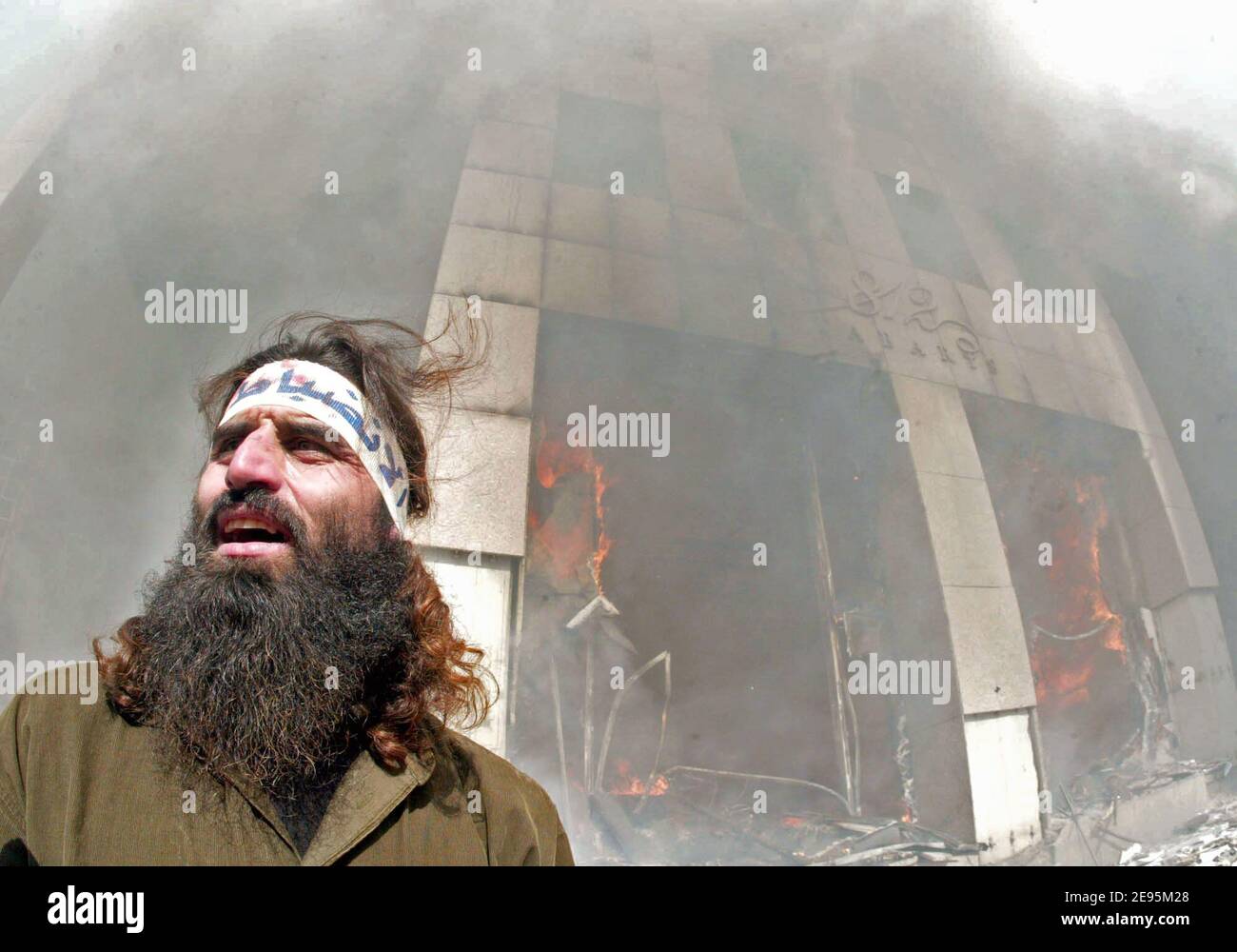 A Muslim protestor stands in front of a burning office building in the Christian neighborhood of Ashrafieh in Beirut on February 5, 2006. A protest by Islamic groups against a Danish cartoon depicting the prophet Mohamed as a terrorist escalated when some of the rioters set fire to the Danish embassy as well as to buildings and cars. Photo by Michael Dohrn/ABACAPRESS.COM Stock Photo