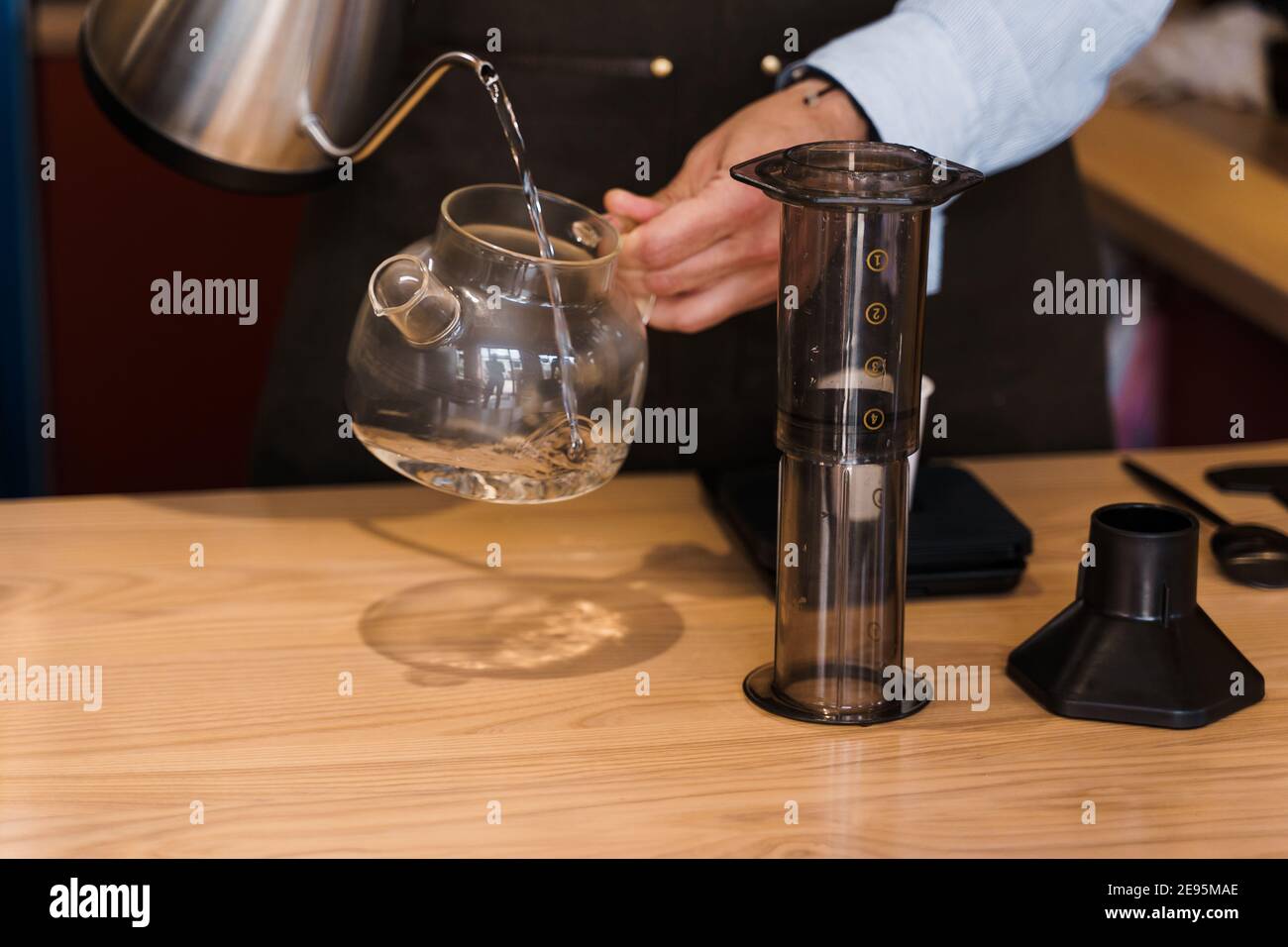 Aeropress coffee: barista press to device and coffee drops pours trought  aeropress to pot. Alternative coffee brewing method. Vertical photo  handsome Stock Photo - Alamy