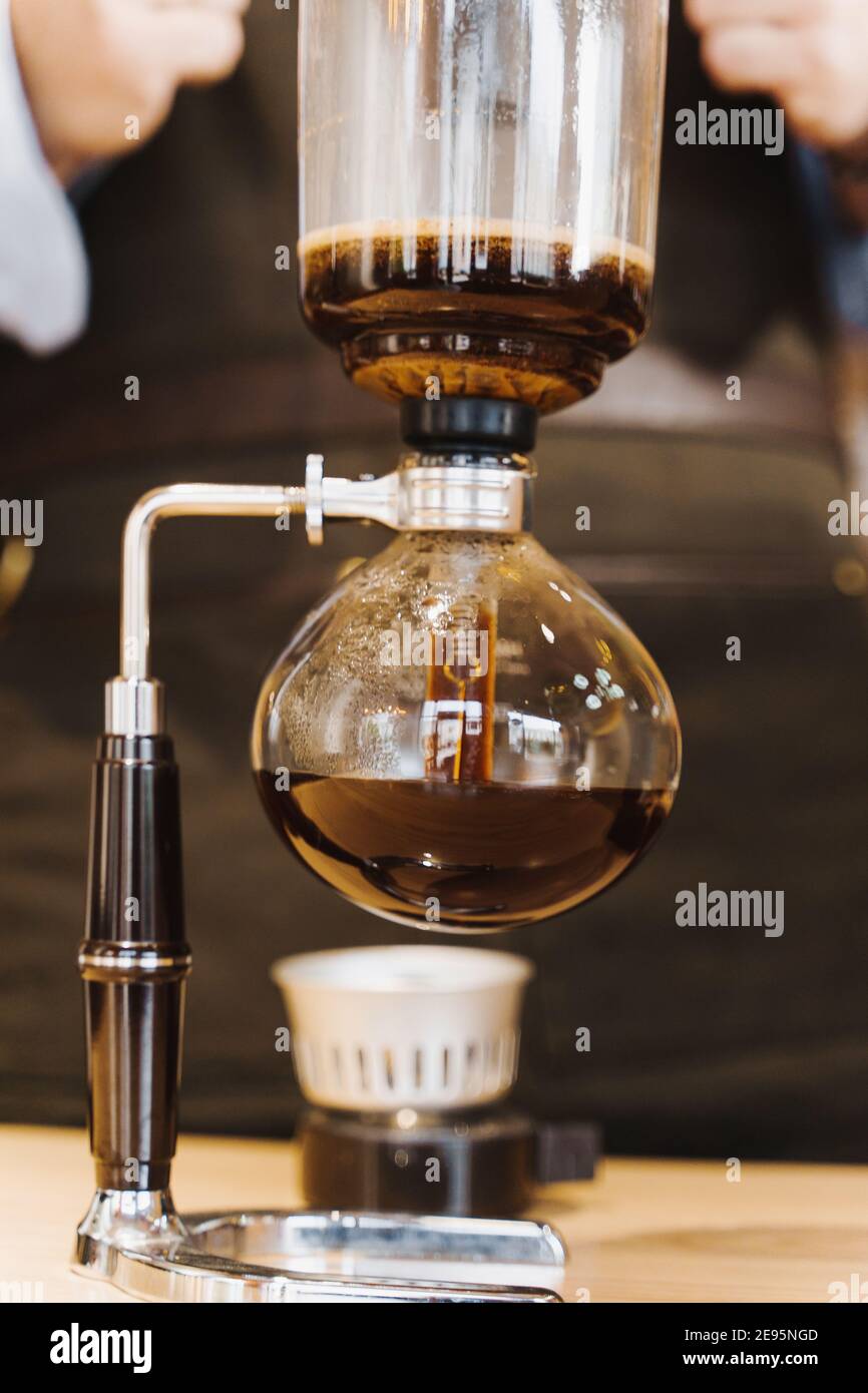 Syphon coffee closeup heats on the fire. Coffee brewing with using