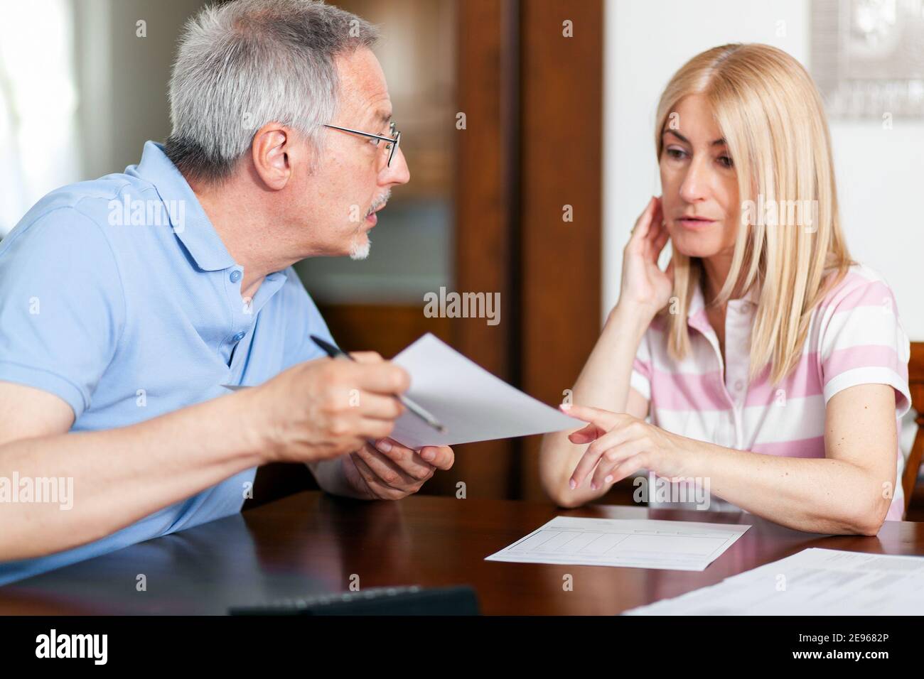 Mature couple checking finances while looking at bills Stock Photo