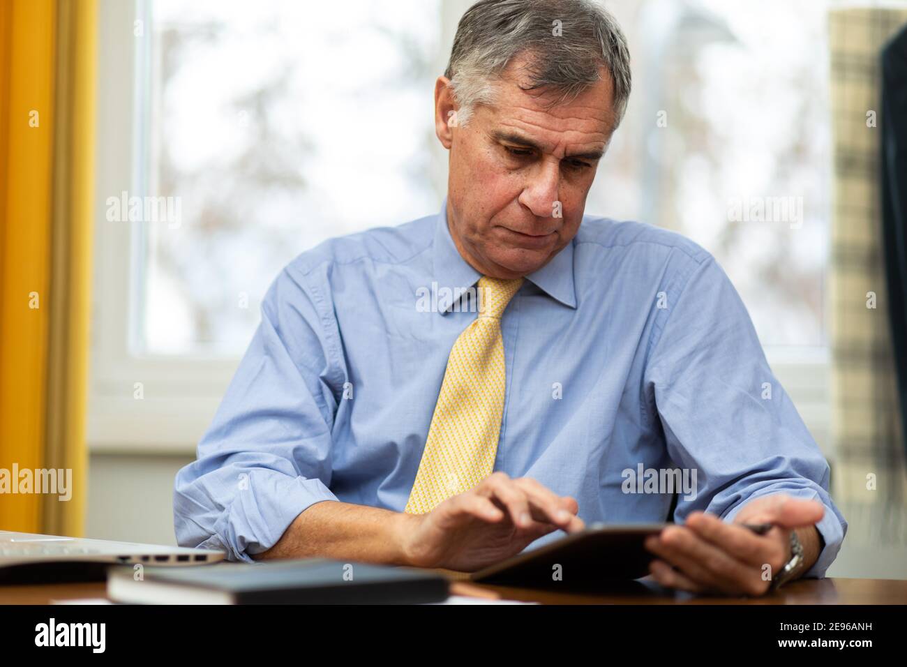 Serious senior businessman reading business documents in office. Senior ...