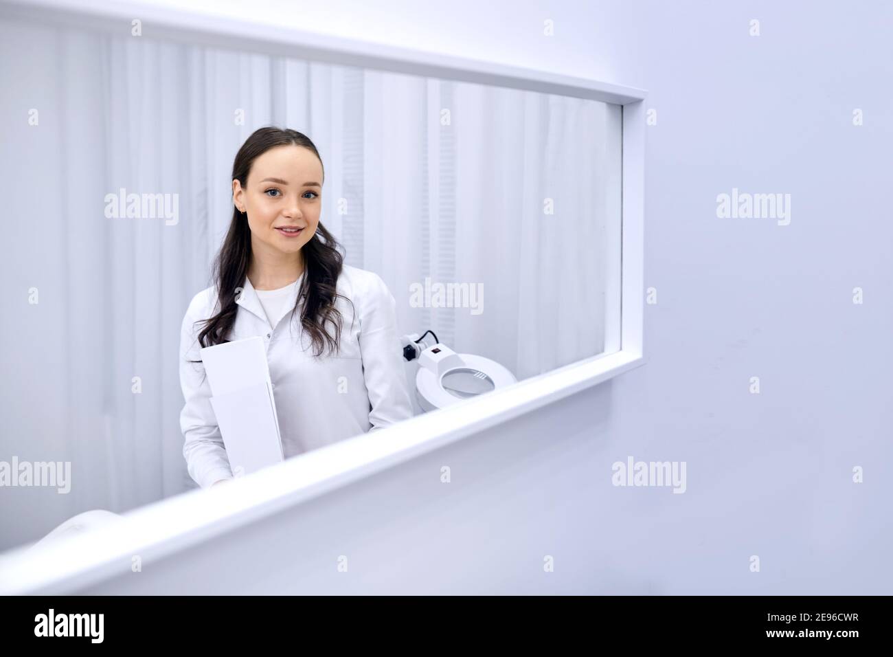 Portrait young beautiful cosmetologist in cosmetology cabinet. Beautiful caucasian woman on a cosmetology procedure. Wellness center. Healthcare, clin Stock Photo