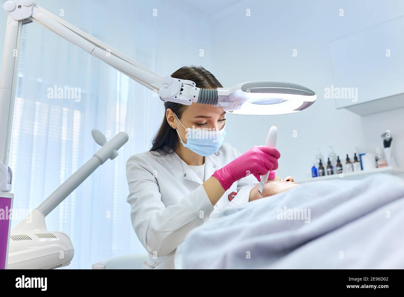 A professional beautician performs a mechanical facial cleansing procedure at the spa. Beautiful caucasian woman on a cosmetic procedure. health Cente Stock Photo