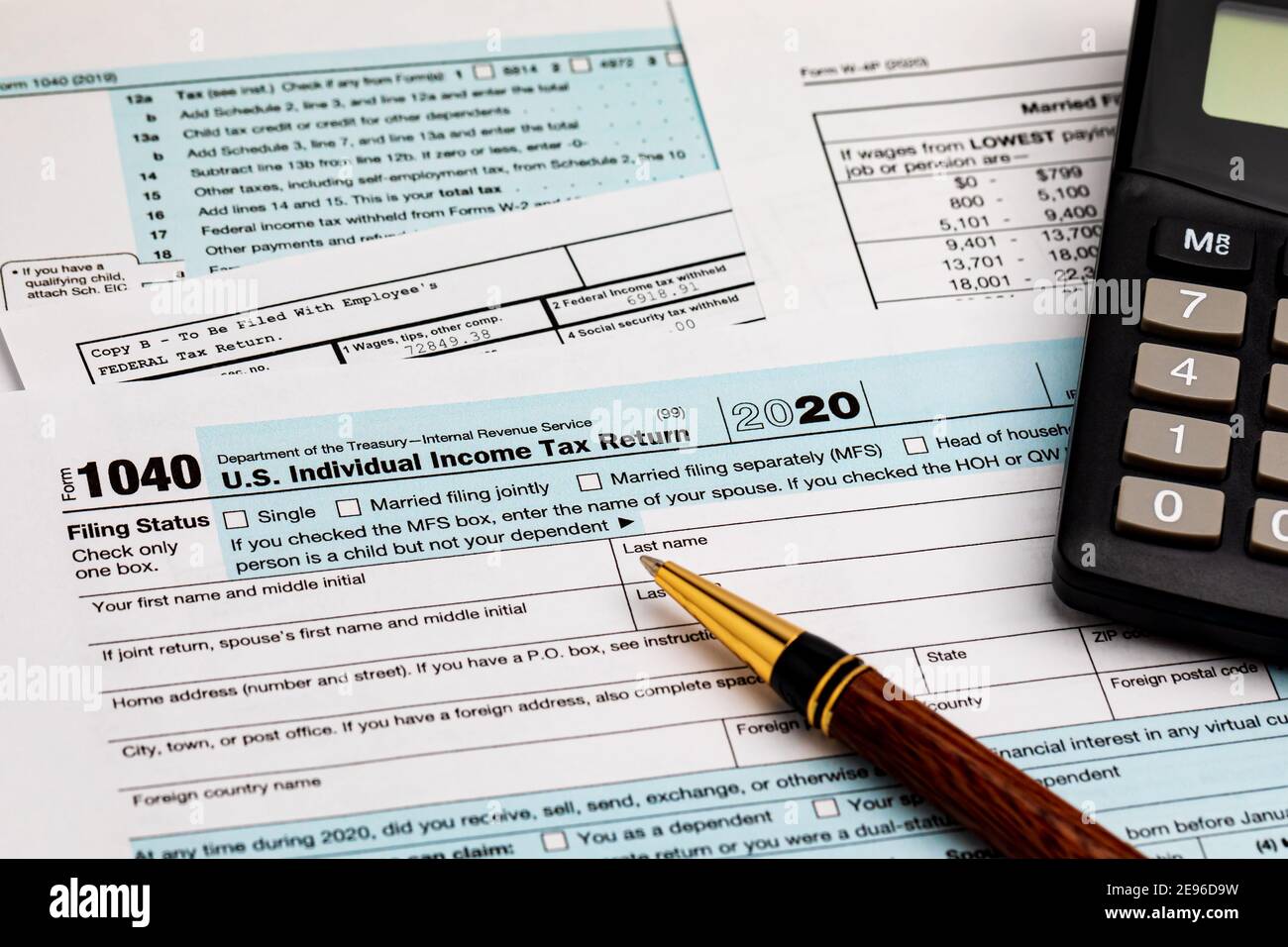 1040 individual income tax return forms, W-2 wage statement and calculator.  Concept of income taxes and federal tax information Stock Photo - Alamy