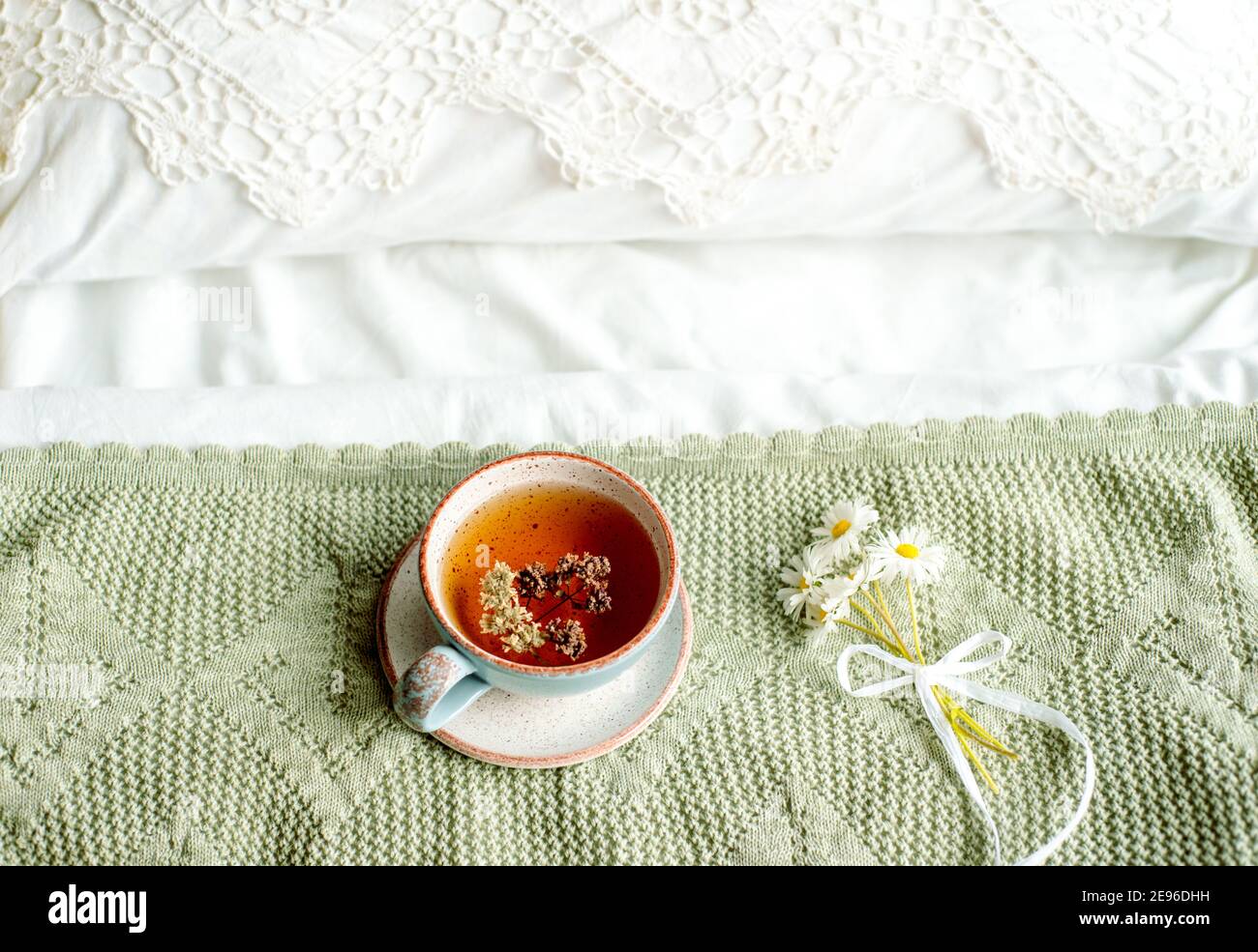 Laptop, a cup of tea,White bed and plaid. sunny morning and breakfast. work online in a comfortable home. cozy bright room. Stock Photo