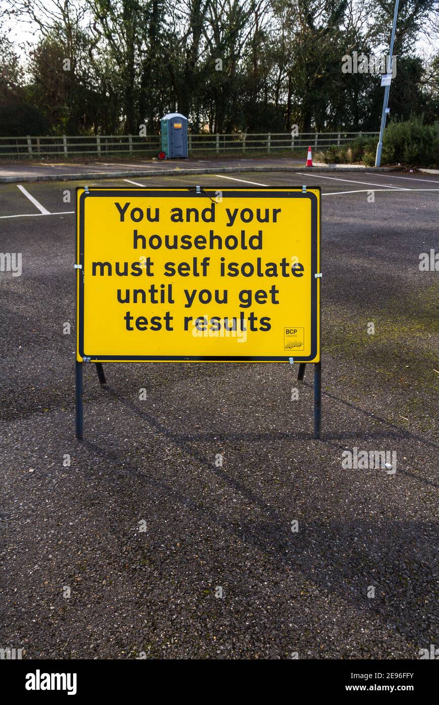 BOURNEMOUTH, ENGLAND - JANUARY 17 2021: Sign at Covid-19 testing site  You and Your Household must Self Isolate until you get test results, portrait, Stock Photo