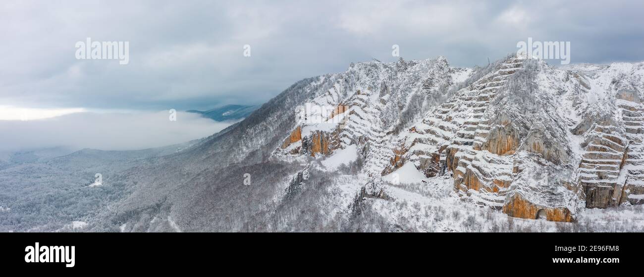 Bélapátfalva, Hungary - Aerial panoramic view of the famous Bélkő mountain on a foggy cloudy winter morning. Aerial winter landscape. Stock Photo