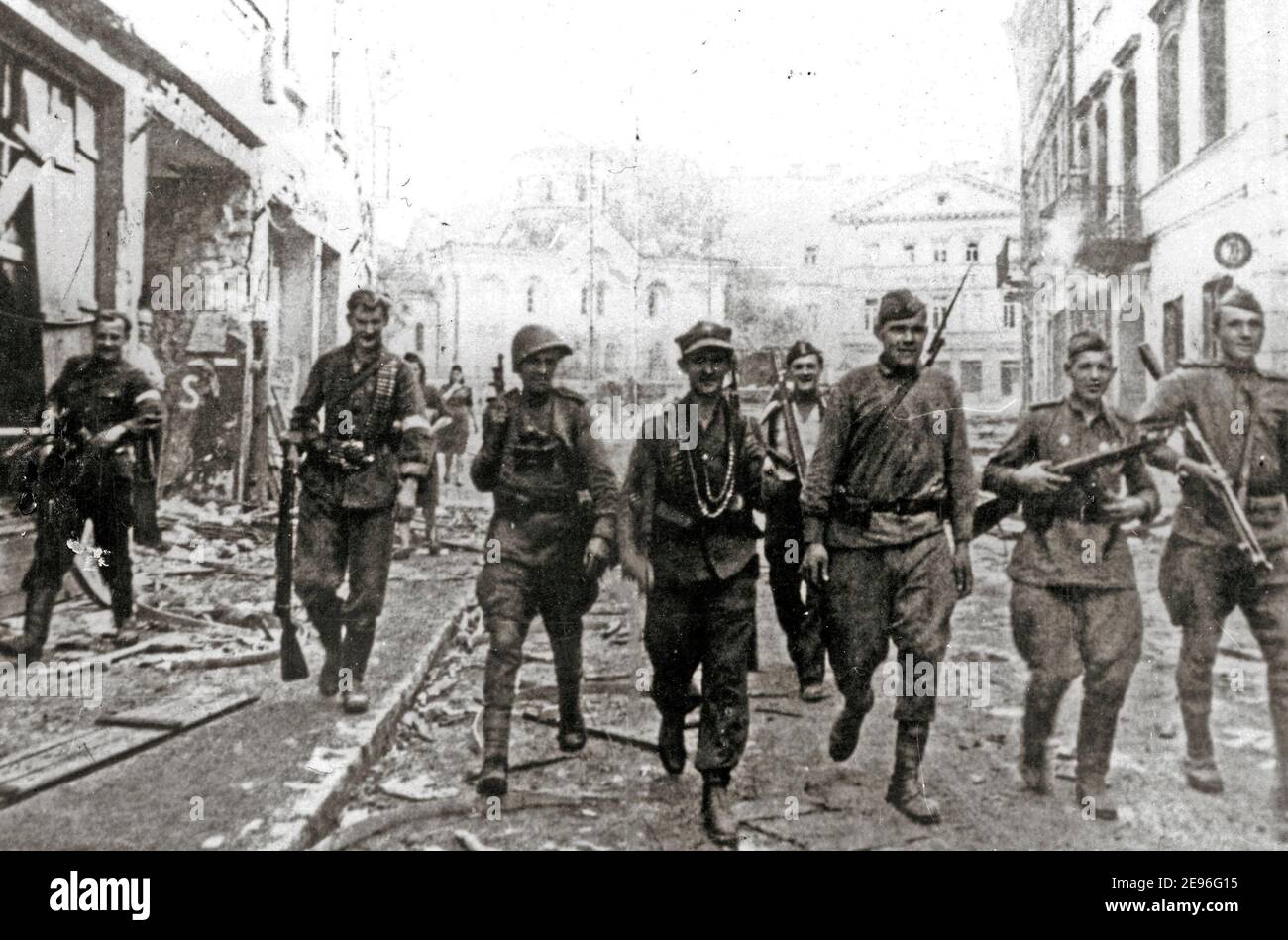 Battle of Vilnius. Soviet and Polish Armija Krajowa Soldiers patrolling along the Large Street. The orthodox church of Vilnius is visible in background, July 1944 Stock Photo