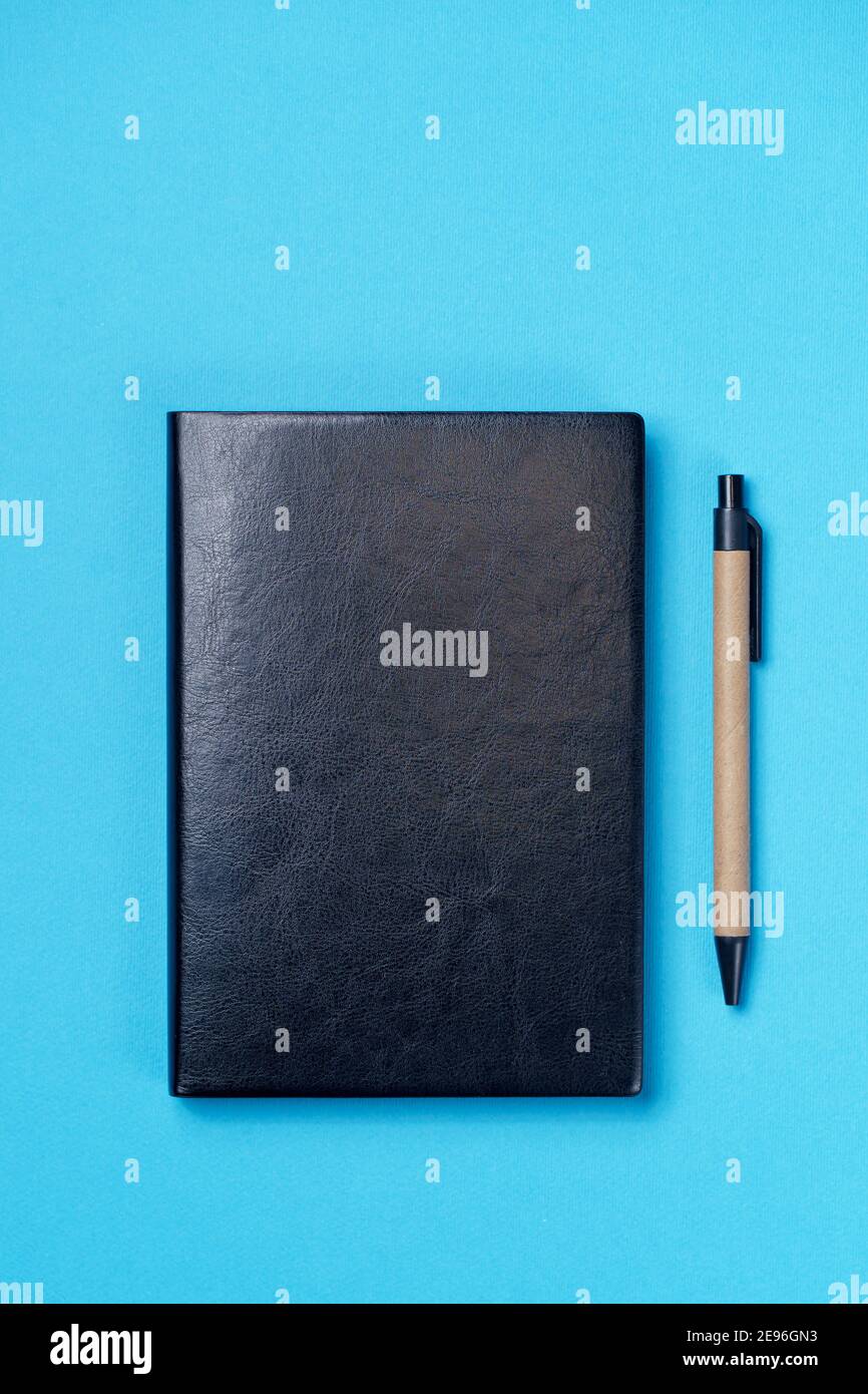 Black leather notebook on a paper blue background, notepad mock up, top