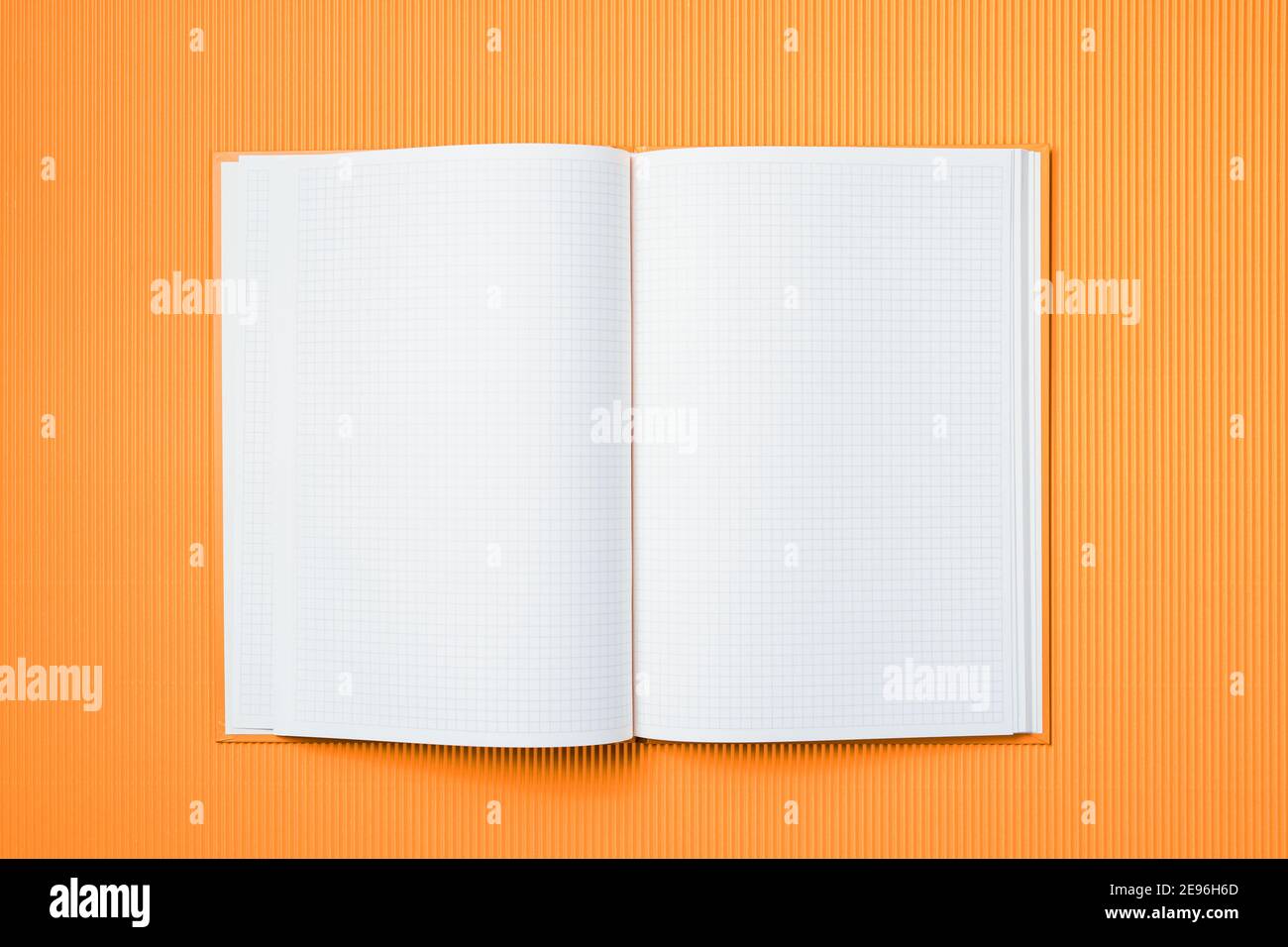 School notebook on a paper orange background, opened notepad and craft ...