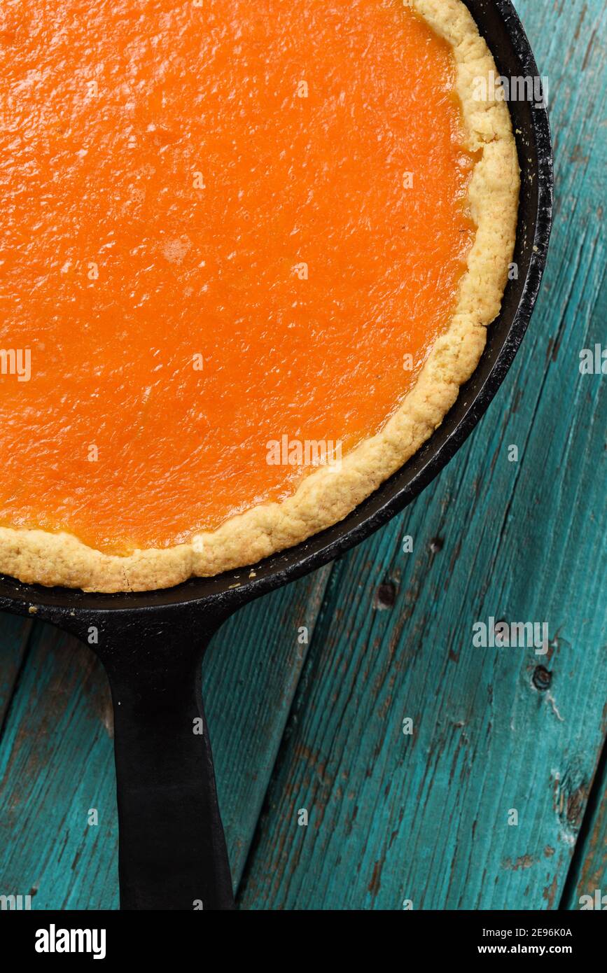 Homemade bright orange pumpkin pie in cast iron pan copyspace top view Stock Photo