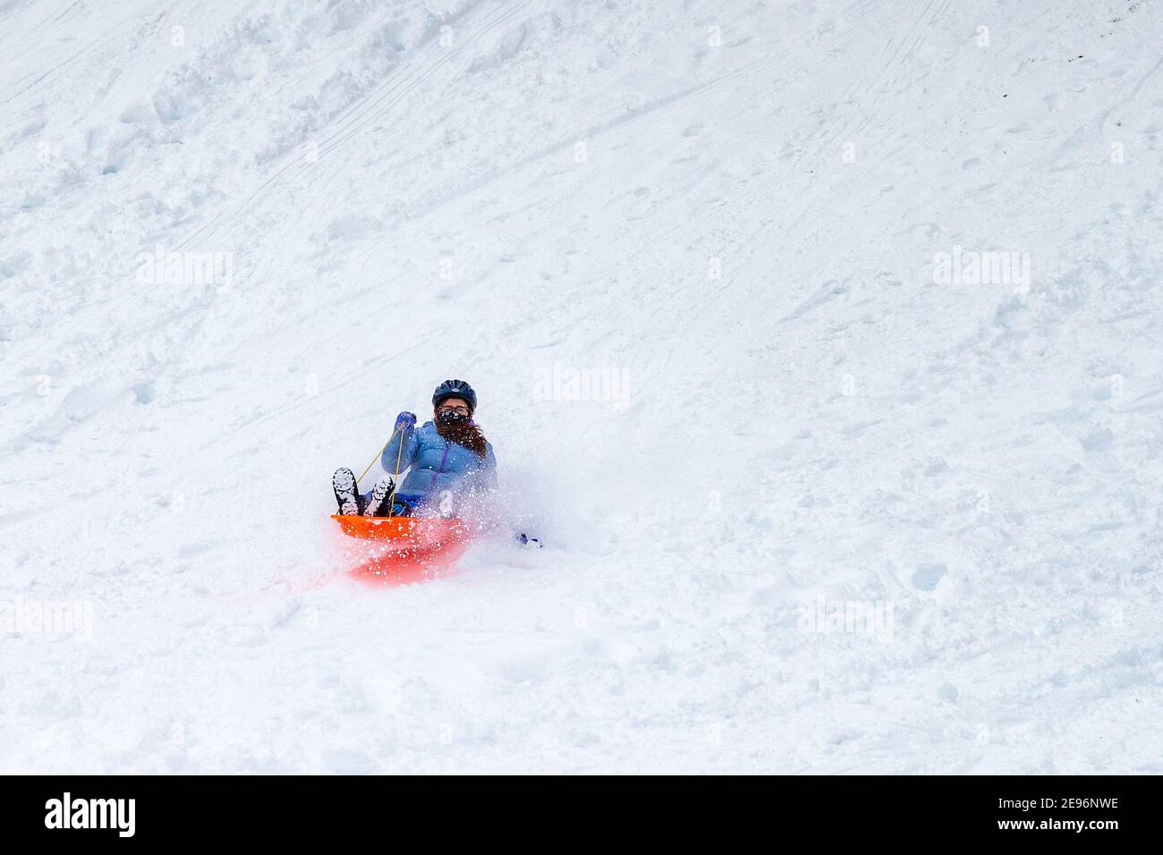 Danville, Pennsylvania, USA. 2nd Feb 2021. A teenager sleds down a hill on the campus of the