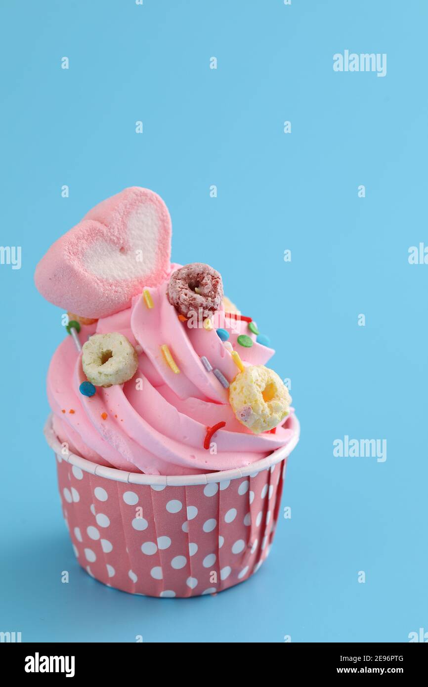 pink cupcake isolated in blue background Stock Photo - Alamy