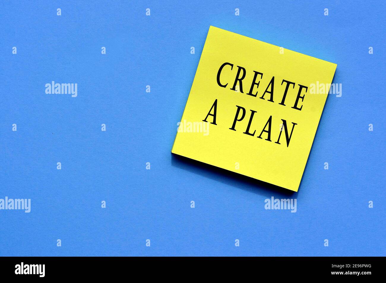 Create a plan text on yellow sticky note with blue background Stock Photo