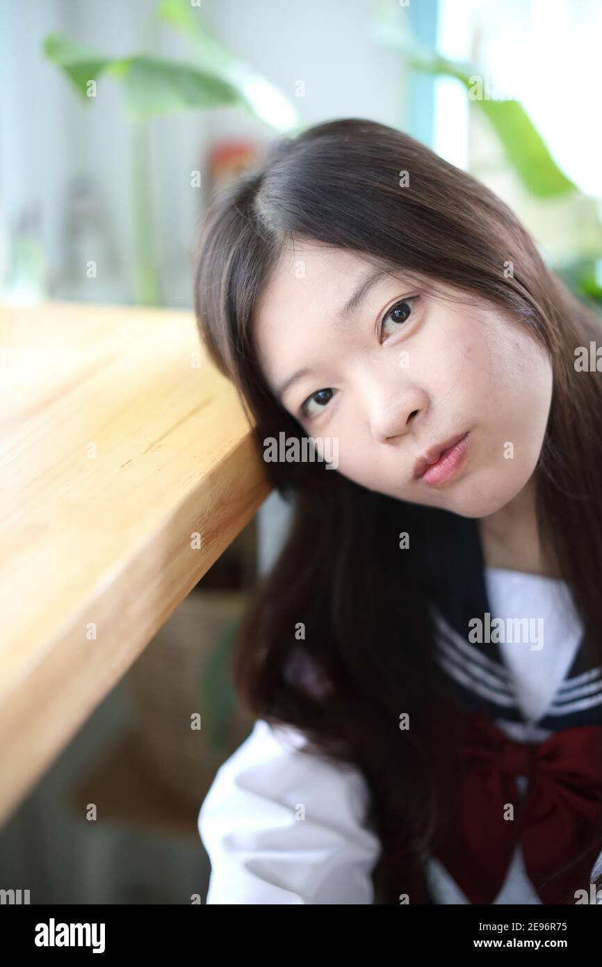 Japanese school girl sitting in local coffee shop Stock Photo