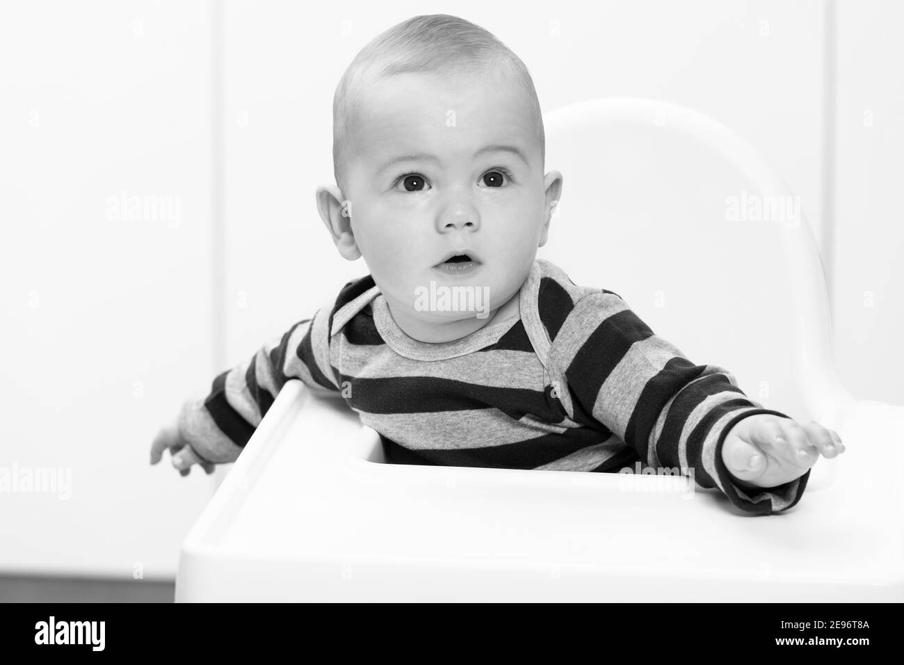 Little Baby Boy Sit on a Chair and Ready to Eat and Looking for Mom Stock Photo