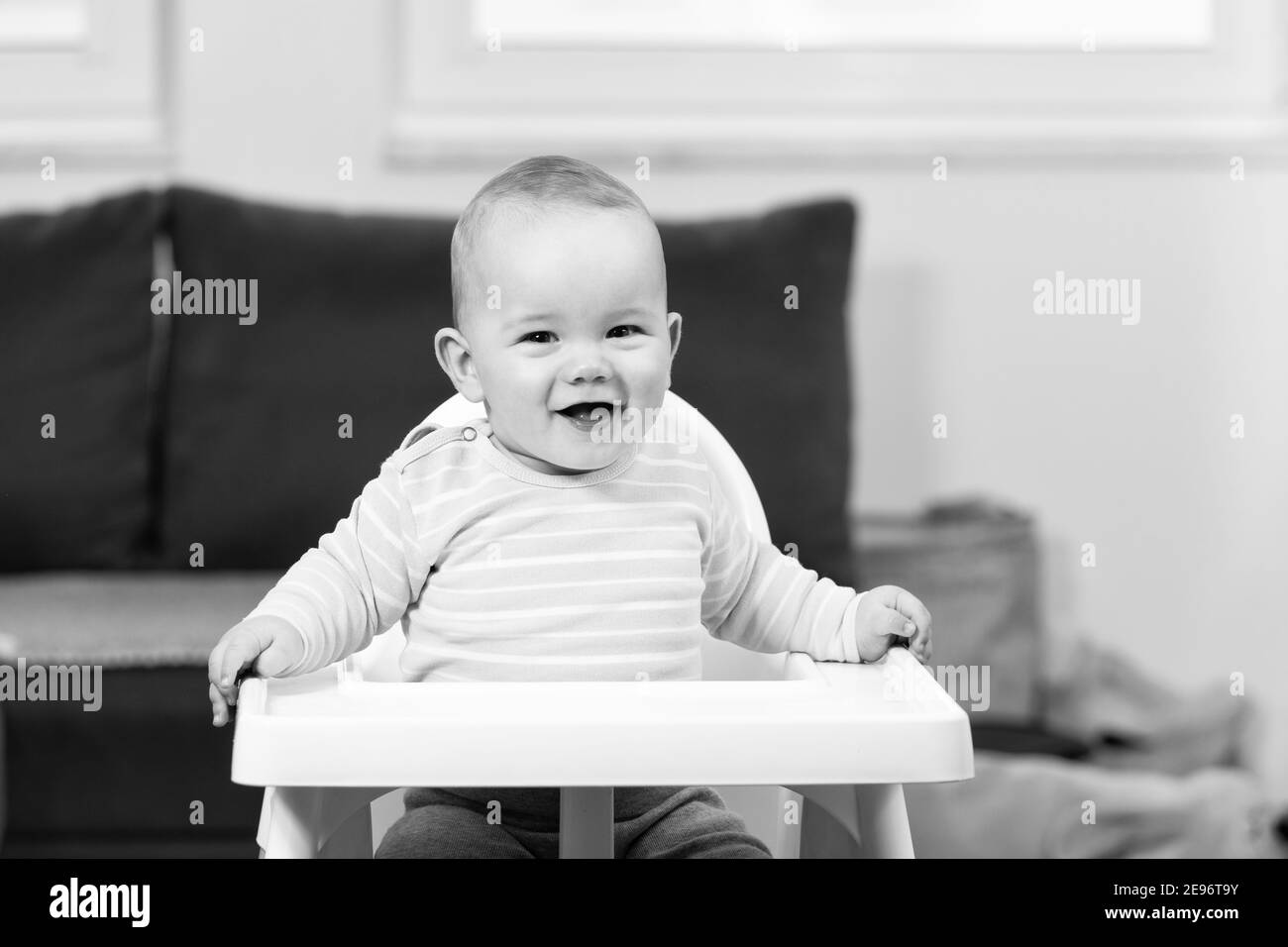 Portrait of a Joyful Baby Sitting on a High Chair Stock Photo