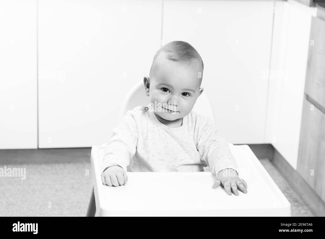 Little Baby Boy Sit on a Chair and Ready to Eat and Looking for Mom Stock Photo