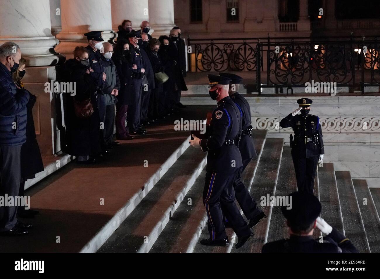 An honor guard carries an urn with the cremated remains of U.S. Capitol Police officer Brian Sicknick and a folded American flag up the steps of the U.S Capitol to lie in honor in the Rotunda, Tuesday, Feb. 2, 2021, in Washington, as Senate Majority Leader Chuck Schumer of N.Y., and House Speaker Nancy Pelosi of Calif., left, and the family, right. watch. Credit: Alex Brandon/Pool via CNP/MediaPunch Stock Photo