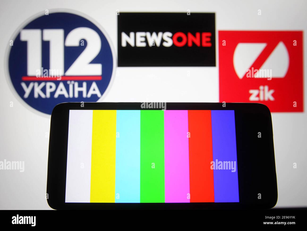 In this photo illustration a rainbow TV test pattern without broadcast on Zik TV channel is seen displayed on a mobile phone screen in front of 112 Ukraine, NewsOne and ZIK logos of Ukrainian TV channels.112 Ukraine, NewsOne and ZIK Ukrainian TV channels are blocked in Ukraine, as Ukraine's media reported late evening on February 02. Ukrainian President Volodymyr Zelensky has put into force a decision by the National Security and Defence Council of February 2, 2021, on applying sanctions against lawmaker Taras Kozak, who is believed to be an ally of pro-Russian politician and the Chairman of t Stock Photo