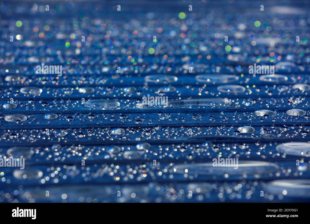 beautiful sparkling, twinkling water drops on dark table slats, abstract background design Stock Photo