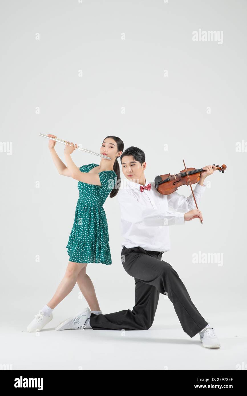 Asian couple contemporary dancers playing violin and flute Stock Photo -  Alamy