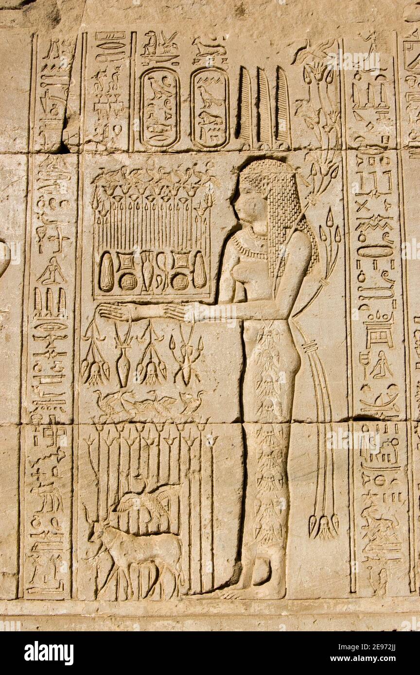 Ancient Egyptian carving on the wall of Dendera Temple of a priestess offering to the goddess Maat. Ancient carving, over 1000 years old. Stock Photo