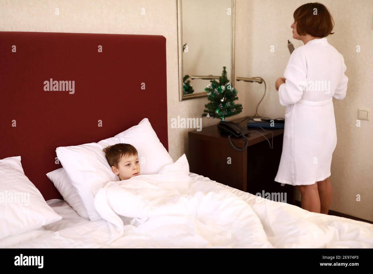 Mother and son share bed in hotel
