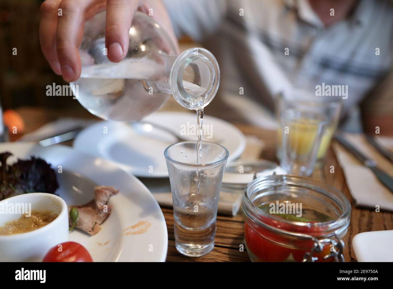 Bartender pouring vodka from the decanter in the pub Stock Photo Alamy
