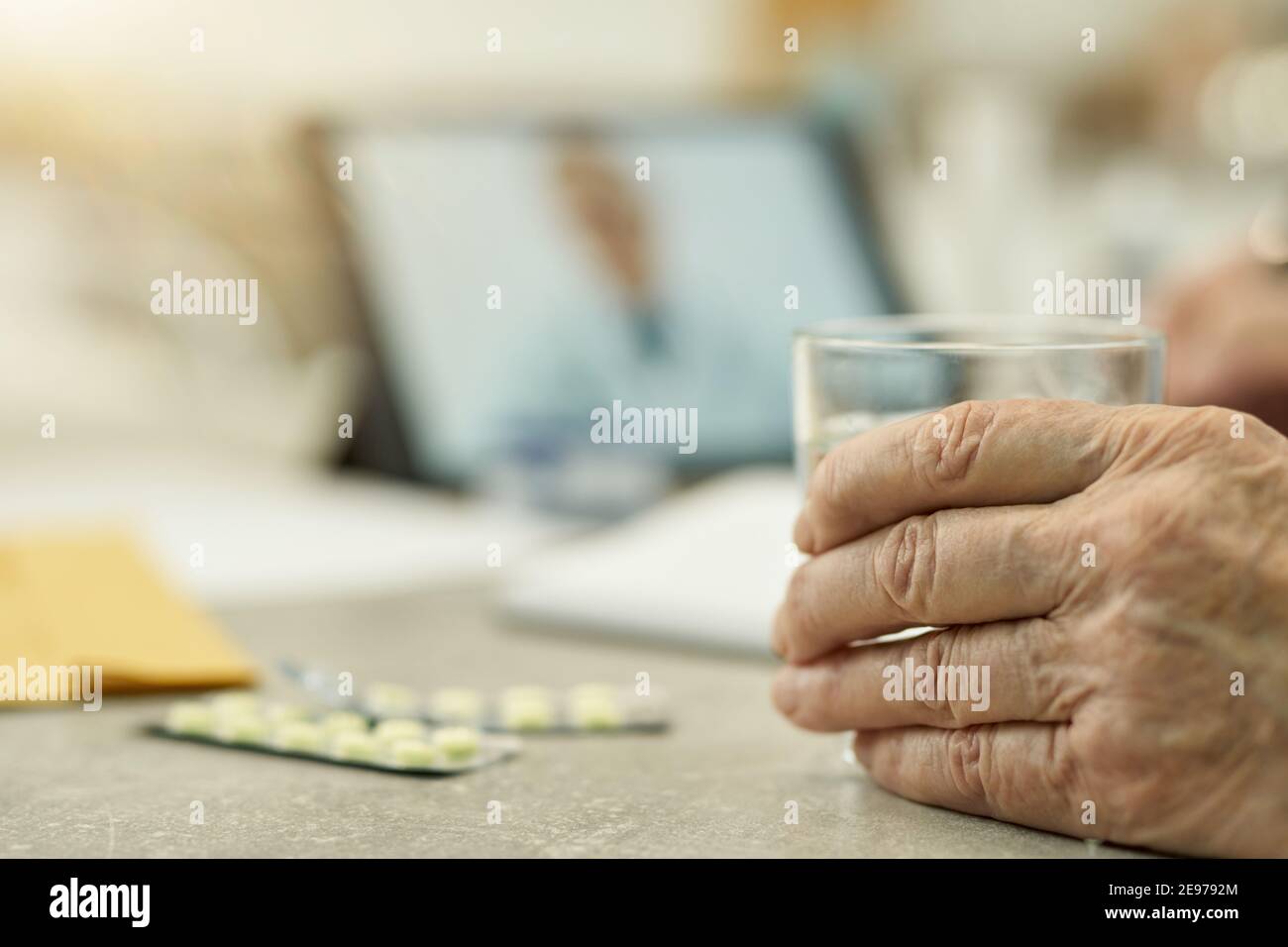 Copy-space photo of hand of a senior citizen holding a glass with water ...
