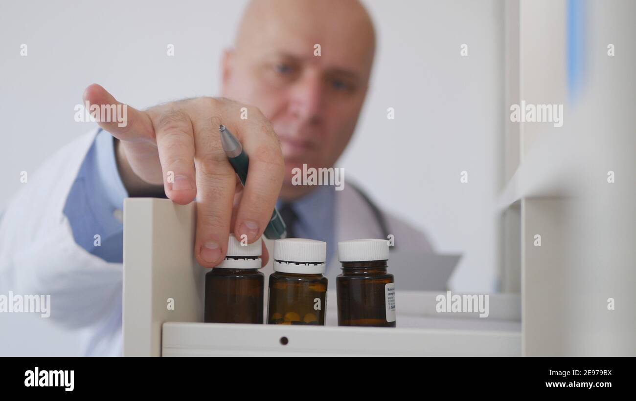 Doctor in Hospital Room Searching Medicaments, Pills and Drugs Stock Photo