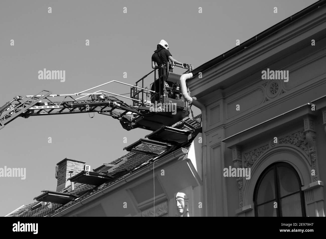 Firefighters intervention on a rooftop of a classic apartment building (B/W) Stock Photo