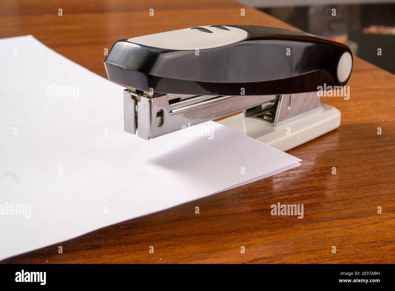 a stack of white paper is stapled together with a stapler Stock Photo