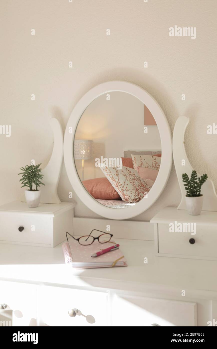 Detail of makeup dressing table with large mirror, diary and organizer. White and clean workstation in the master bedroom. Nobody inside. Stock Photo