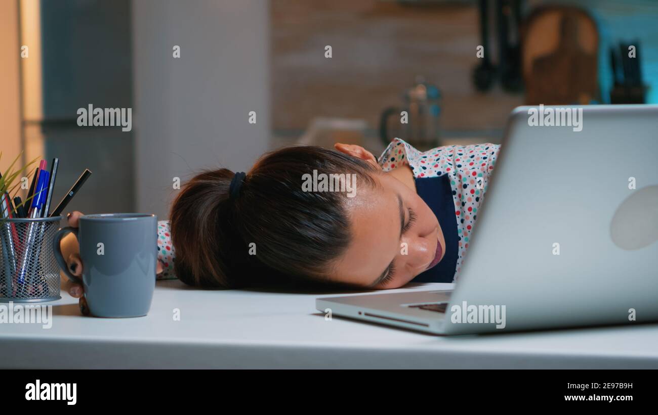 Exhausted overload business woman falling asleep on desk with open