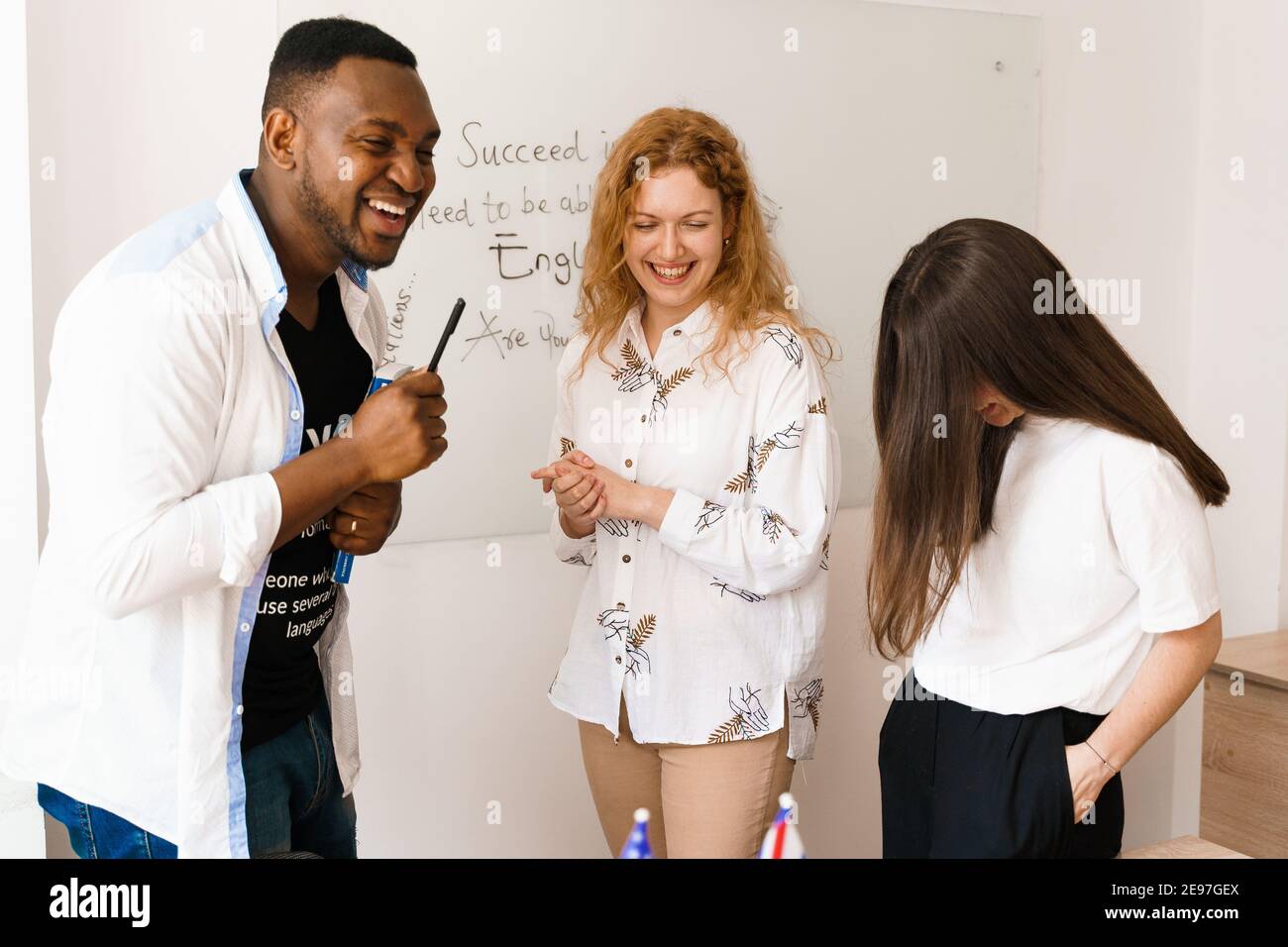 Multiethnic students and teacher study foreign languages together in class. Studing with laptop. Black handsome student study with white people togeth Stock Photo