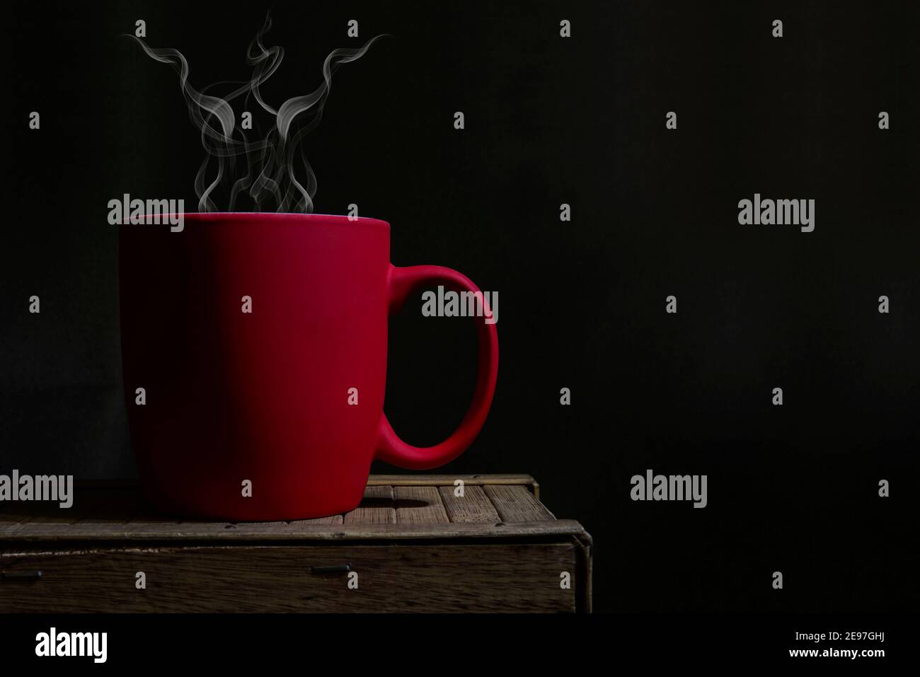 Red coffee cup with hot steam coming out making aroma in office. Stock Photo