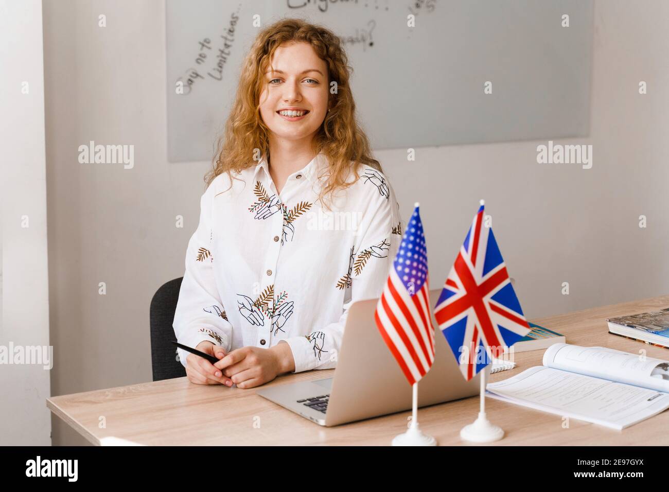 Close-up portrait of a beautiful smiling student on bright background. Happy ginger female teacher smiling to her colleagues Stock Photo