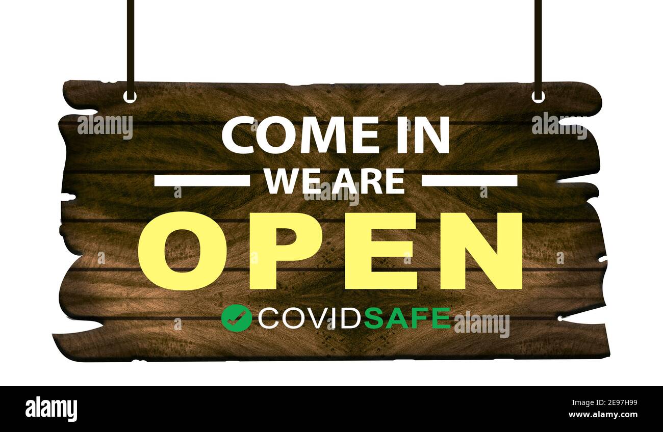 Come in we are open with covid safe rules sign hanging on shop front. Stock Photo