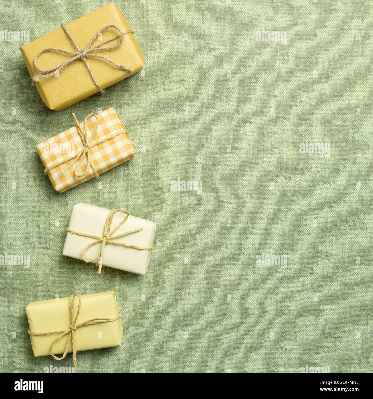 Yellow gift boxes on green fabric background. flat lay, top view, copy