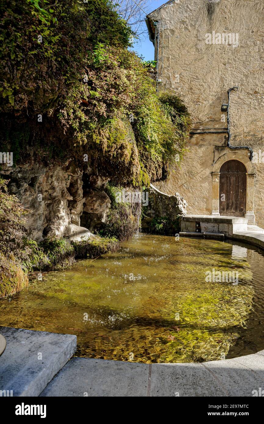 A fountain in Provence. The limestone transported by the water formed a protrusion above the basin. This has gradually become covered with vegetation. Stock Photo