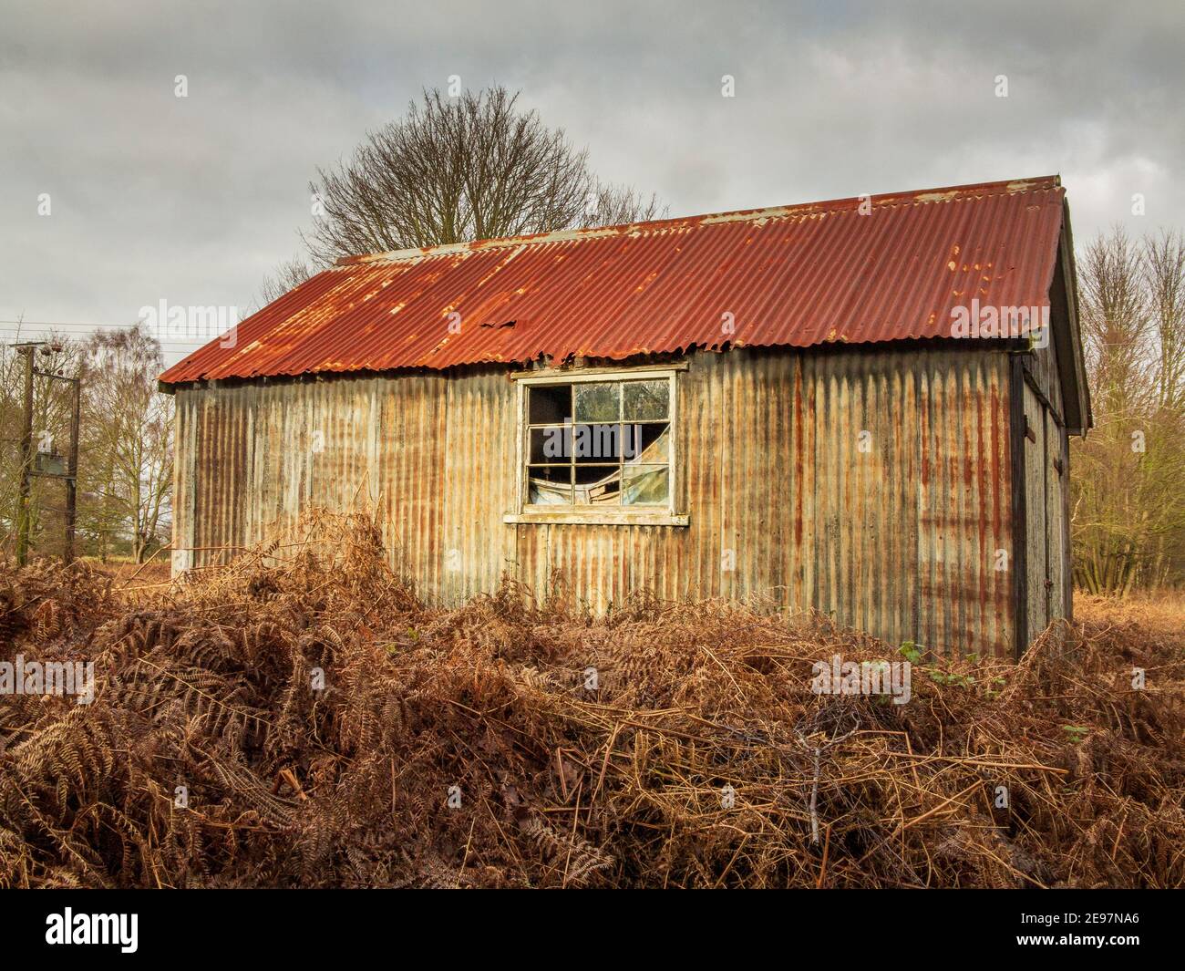 Neglected corrugated metal out building with broken window and rusting structure, giving a creepy feel Stock Photo